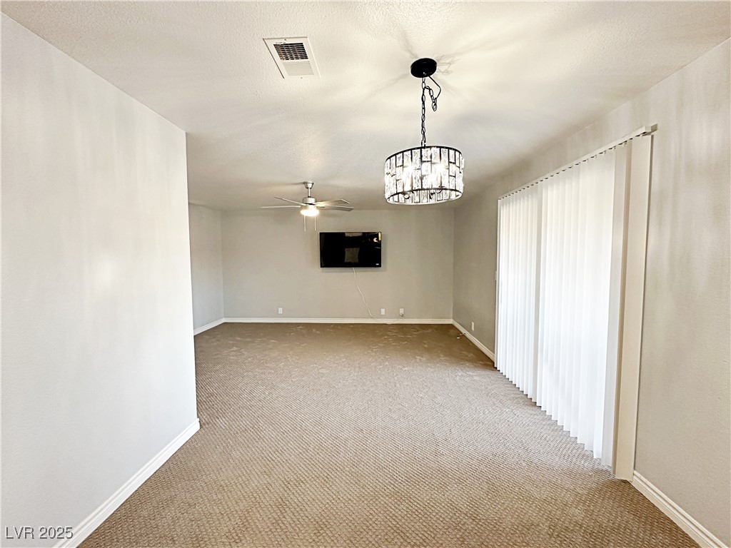 5080 Indian River Drive, Unit 400 Las Vegas, NV 89103 - Photo 12 of 29 Unfurnished room with carpet, a ceiling fan, a chandelier, and a textured ceiling