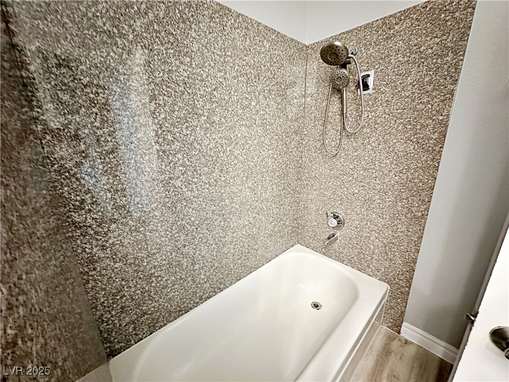 5080 Indian River Drive, Unit 400 Las Vegas, NV 89103 - Photo 18 of 29 Bathroom featuring bathtub / shower combination and wood finished floors