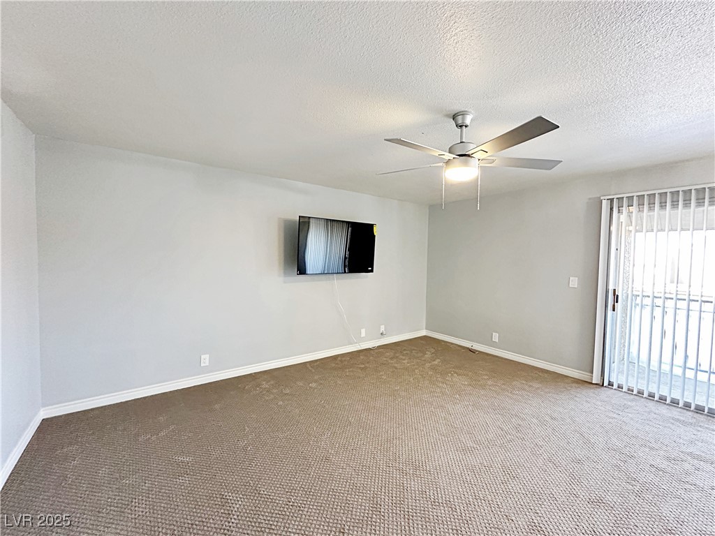 5080 Indian River Drive, Unit 400 Las Vegas, NV 89103 - Photo 4 of 29 Spare room featuring carpet flooring, a textured ceiling, and a ceiling fan