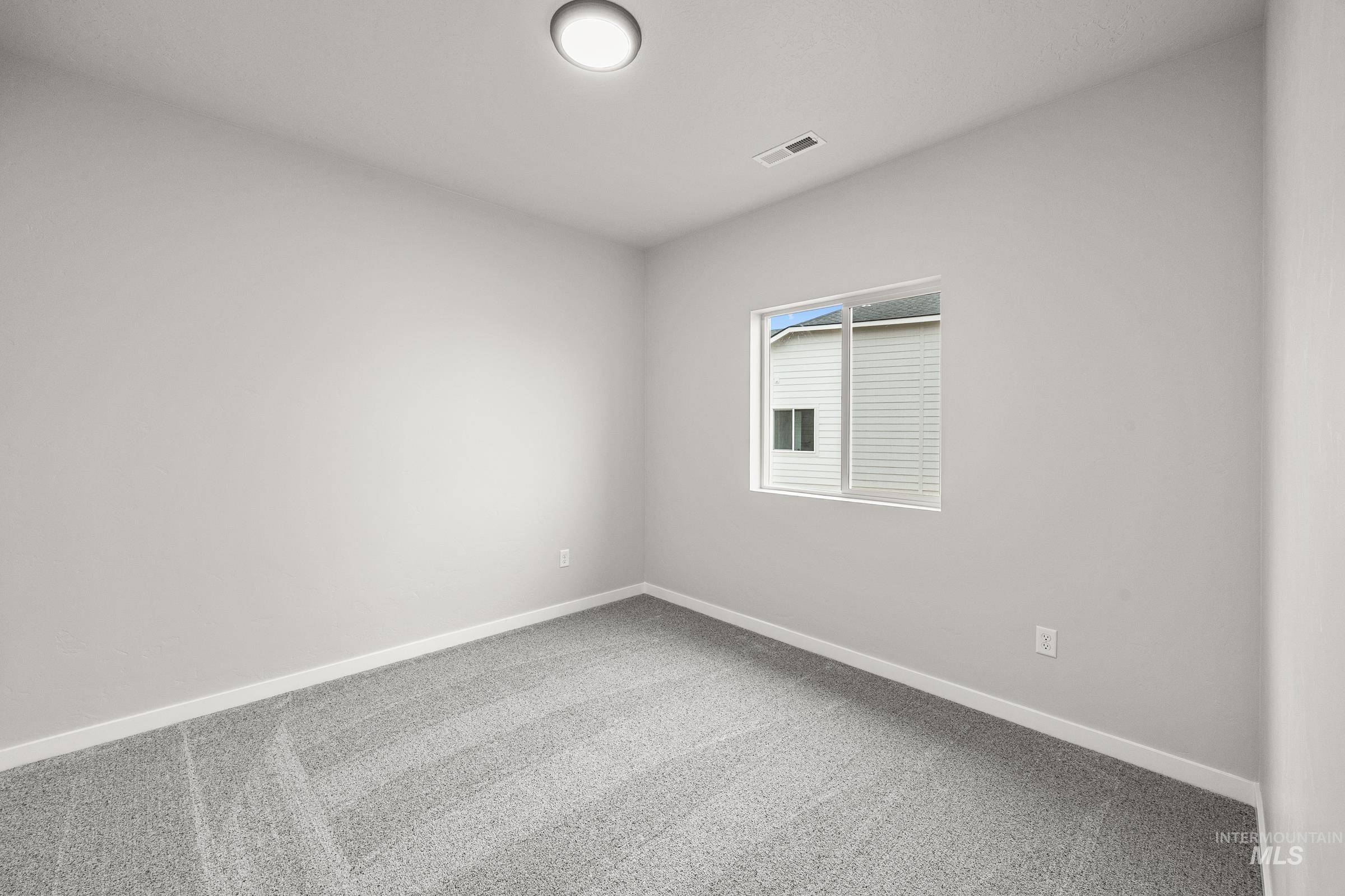 13656 Redway Court Caldwell, ID 83607 - Photo 14 of 21 Neutral tone interior space featuring a window with horizontal blinds, light-colored walls, and carpet flooring