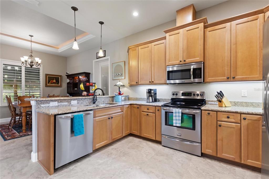 130 Laynewade Road Polk City, FL 33868 - Photo 13 of 41 a kitchen with stainless steel appliances granite countertop a stove top oven a sink dishwasher and a microwave oven with cabinets