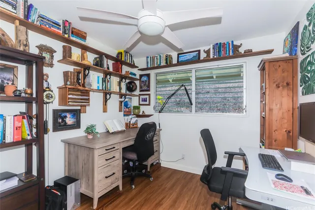 a view of a workspace with furniture and a window