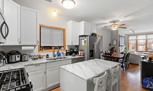 2033 West Huron Street, Unit 1 Chicago, IL 60612 - Photo 4 of 8 a kitchen with a table chairs stove and cabinets