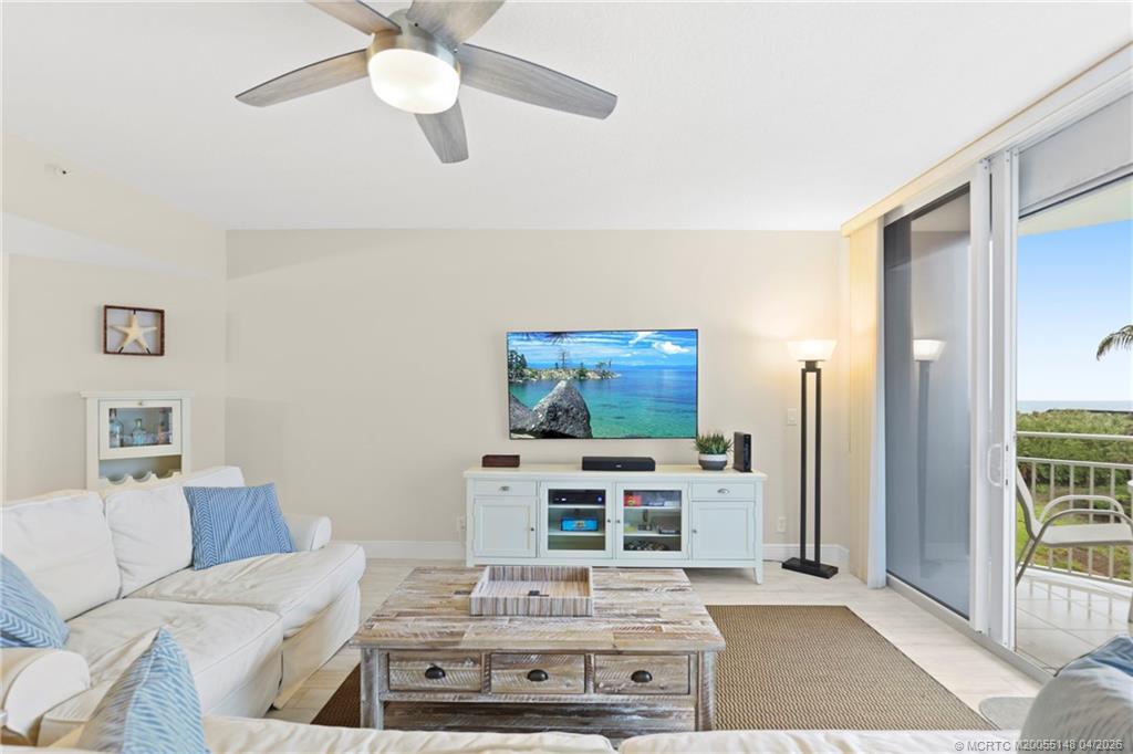 579 Northeast Plantation Road, Unit N107 Jensen Beach, FL 34957 - Photo 11 of 44 a living room with furniture a flat screen tv and a dining table