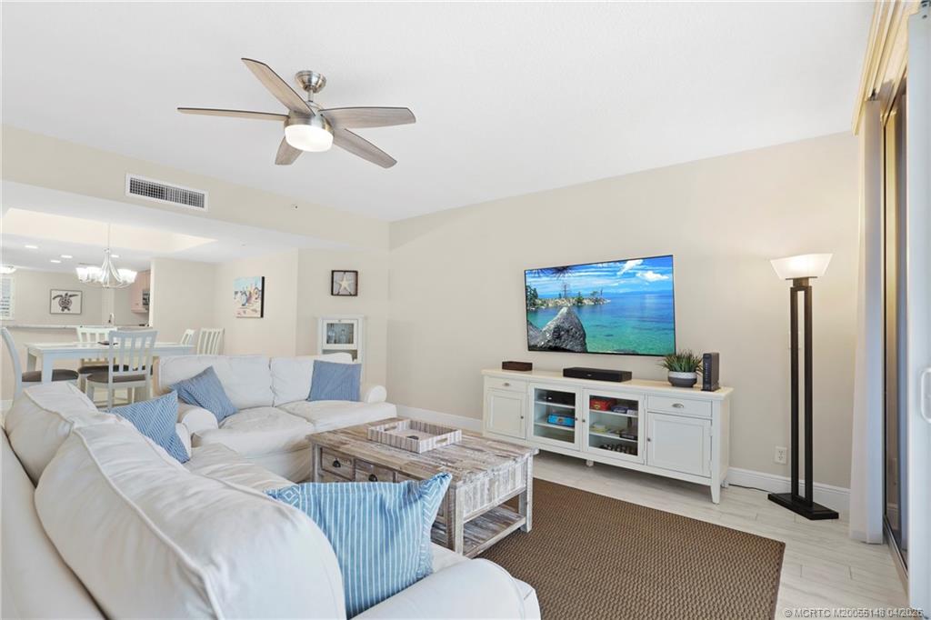 579 Northeast Plantation Road, Unit N107 Jensen Beach, FL 34957 - Photo 12 of 44 a living room with furniture and a flat screen tv
