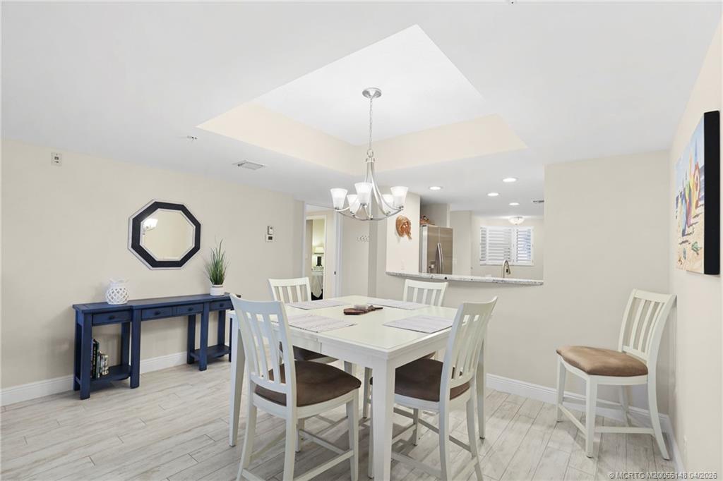 579 Northeast Plantation Road, Unit N107 Jensen Beach, FL 34957 - Photo 21 of 44 a view of a dining room with furniture window and wooden floor