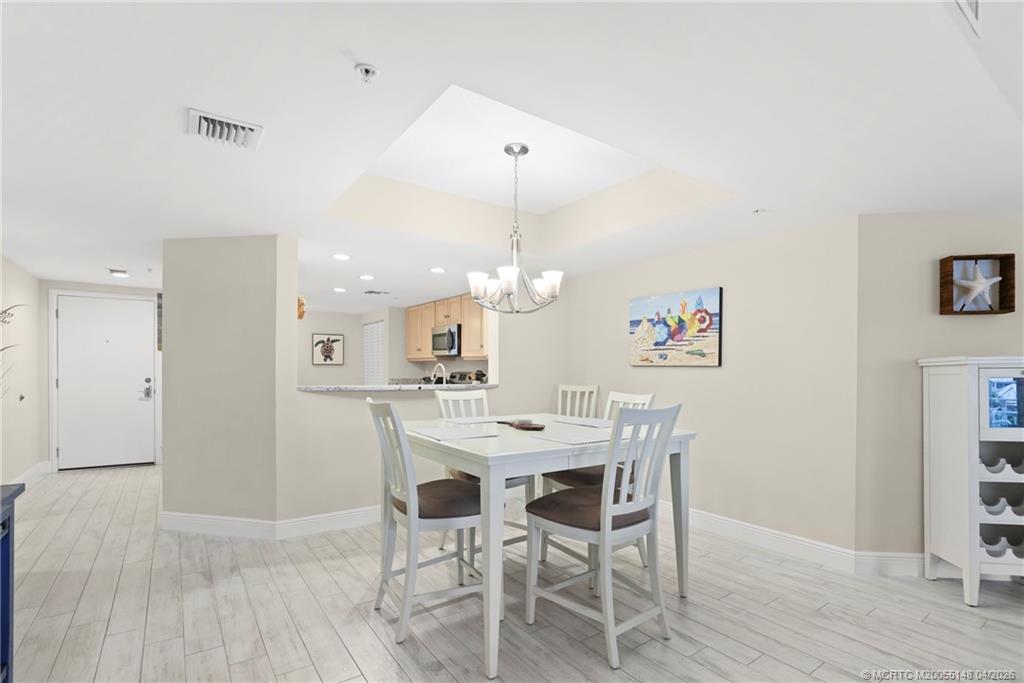 579 Northeast Plantation Road, Unit N107 Jensen Beach, FL 34957 - Photo 23 of 44 a view of a dining room with furniture and wooden floor