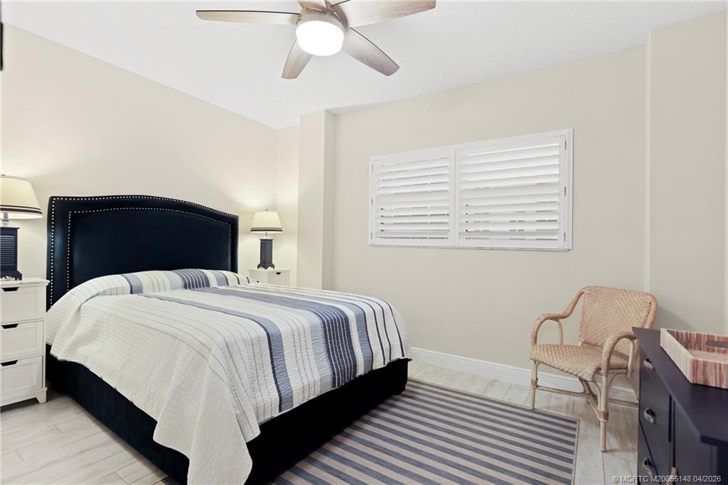 579 Northeast Plantation Road, Unit N107 Jensen Beach, FL 34957 - Photo 24 of 44 a bedroom with a bed lamp and a dresser