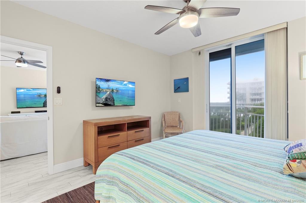 579 Northeast Plantation Road, Unit N107 Jensen Beach, FL 34957 - Photo 27 of 44 a bedroom with a bed and a chandelier