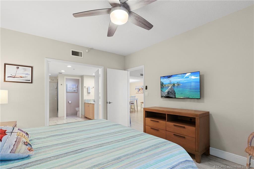 579 Northeast Plantation Road, Unit N107 Jensen Beach, FL 34957 - Photo 28 of 44 a bedroom with furniture and a flat screen tv