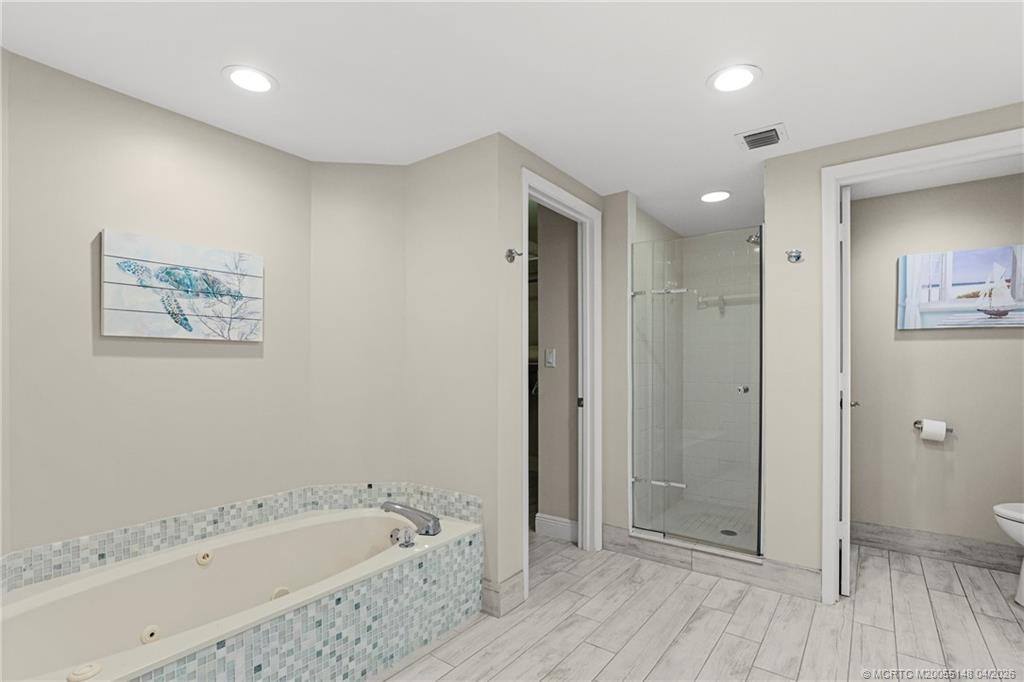 579 Northeast Plantation Road, Unit N107 Jensen Beach, FL 34957 - Photo 30 of 44 a bathroom with a bathtub and a shower