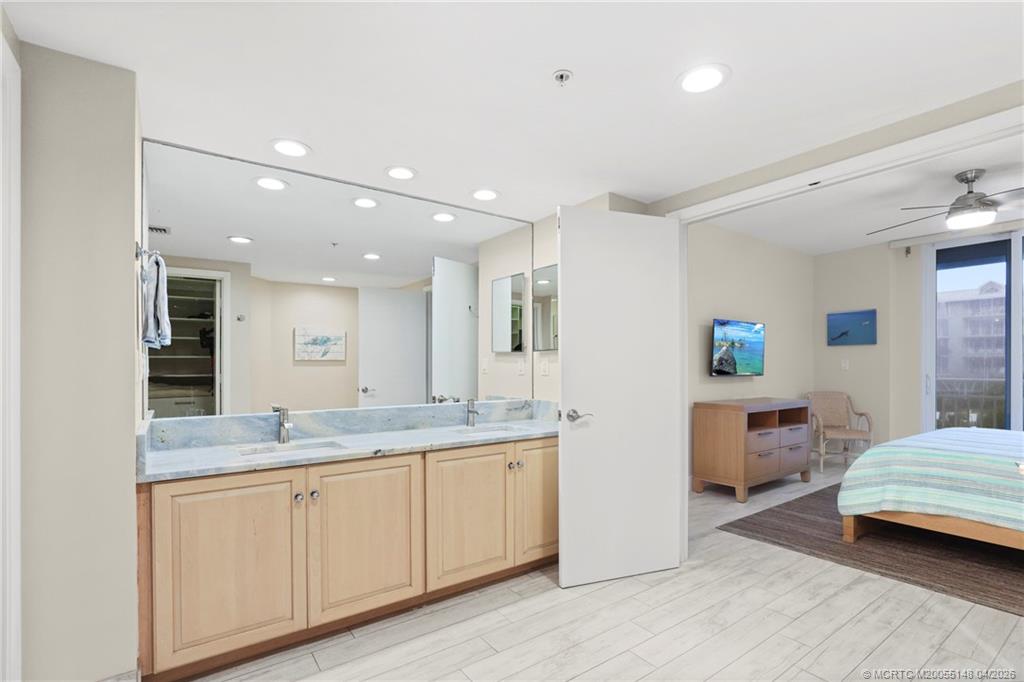 579 Northeast Plantation Road, Unit N107 Jensen Beach, FL 34957 - Photo 32 of 44 a spacious bathroom with a granite countertop sink mirror and toilet