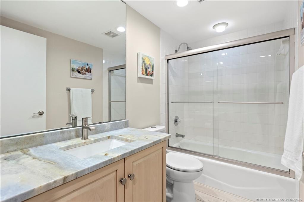579 Northeast Plantation Road, Unit N107 Jensen Beach, FL 34957 - Photo 33 of 44 a bathroom with a granite countertop sink toilet and shower