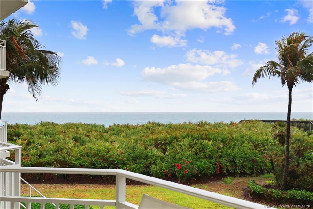 579 Northeast Plantation Road, Unit N107 Jensen Beach, FL 34957 - Photo 35 of 44 a view of a swimming pool and trees in the background