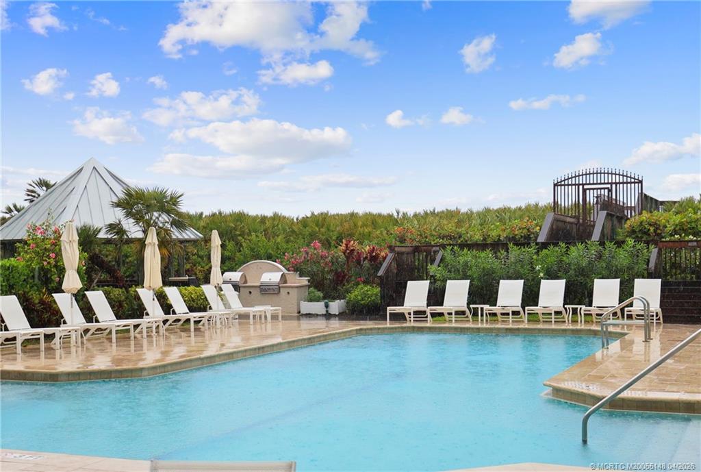 579 Northeast Plantation Road, Unit N107 Jensen Beach, FL 34957 - Photo 43 of 44 a view of a swimming pool with a patio