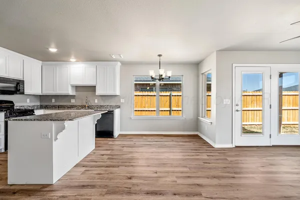 a large kitchen with cabinets wooden floor and stainless steel appliances