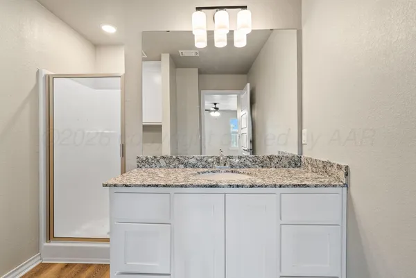 a bathroom with a granite countertop sink a toilet and shower