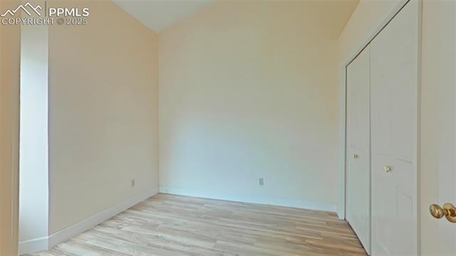 460 Autumn Ridge Circle, Unit D Colorado Springs, CO 80906 - Photo 12 of 38 Unfurnished bedroom with a closet, baseboards, and light wood-type flooring