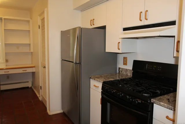 a kitchen with a refrigerator stove and cabinets