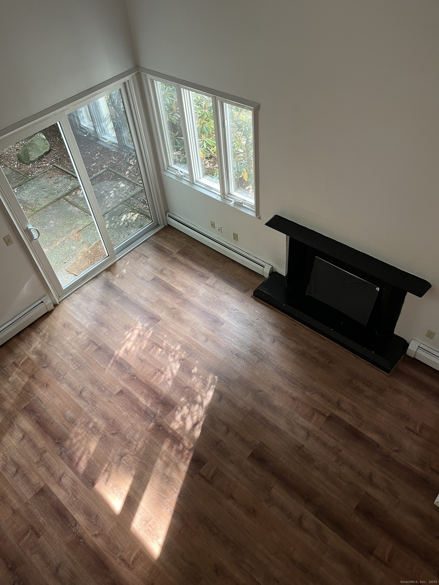 6 Lyle Court, Unit C Farmington, CT 06032 - Photo 26 of 34 a view of an empty room and wooden floor and windows