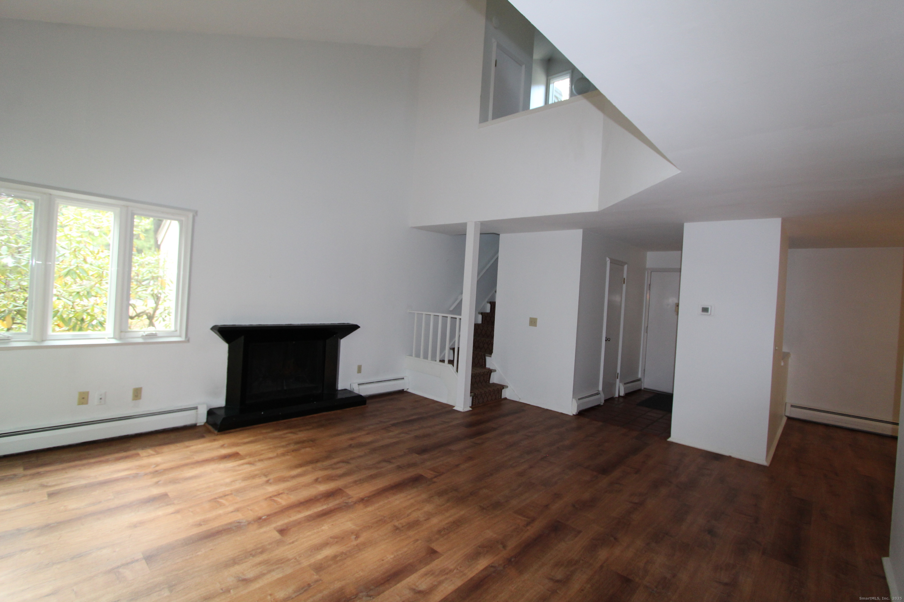 6 Lyle Court, Unit C Farmington, CT 06032 - Photo 7 of 34 a view of empty room with wooden floor and fan