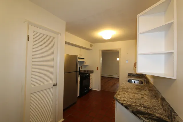 a kitchen with a refrigerator and a stove top oven