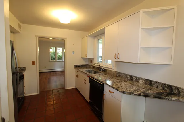 a kitchen with granite countertop a sink and a stove top oven
