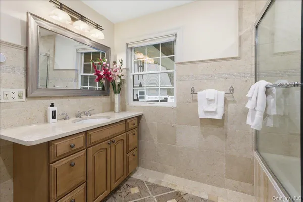 a bathroom with a shower sink and mirror