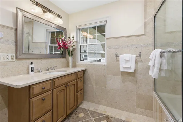 a bathroom with a shower sink and mirror