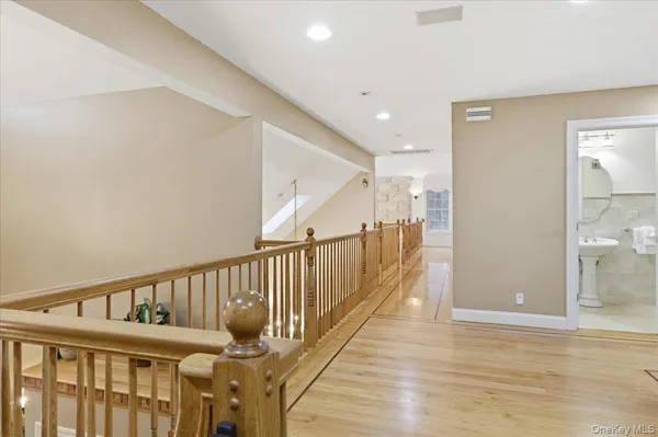 a view of a hallway with wooden floor and staircase