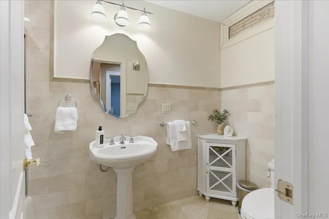 a bathroom with a sink toilet and a mirror