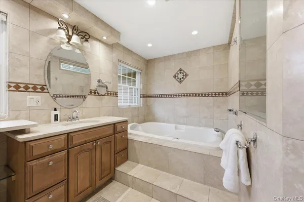 a bathroom with a bathtub a sink and mirror