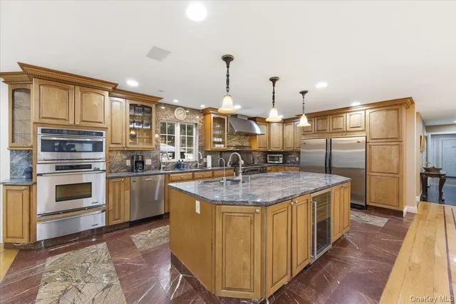 a kitchen with stainless steel appliances granite countertop a sink a stove and a refrigerator