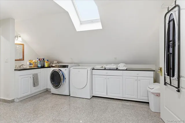 a utility room with cabinets washer and dryer