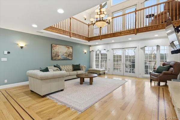 a living room with furniture stairs and a wooden floor