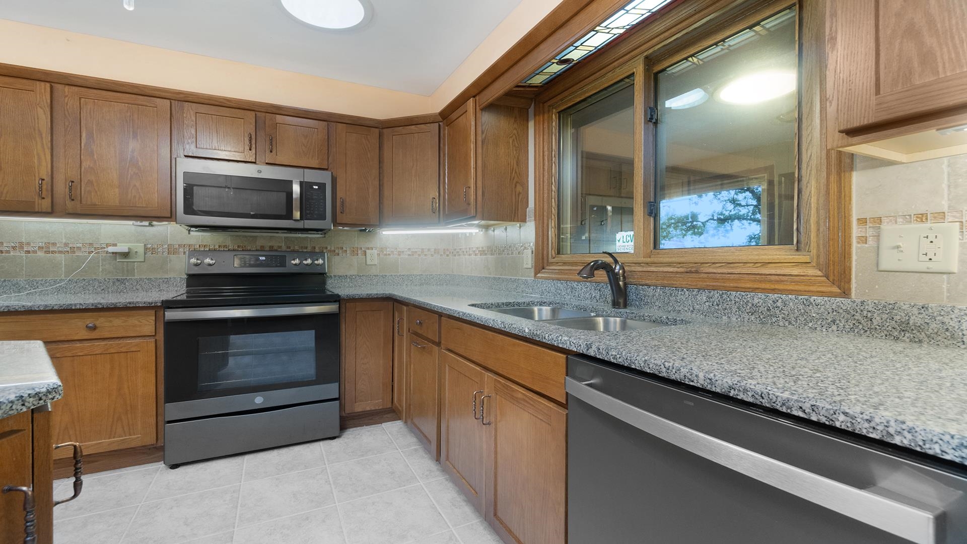 35340 West County Line Road Kirkland, IL 60146 - Photo 15 of 45 a kitchen with granite countertop a sink and stainless steel appliances