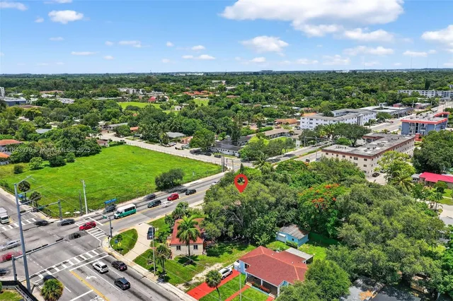 an aerial view of residential houses with outdoor space and trees