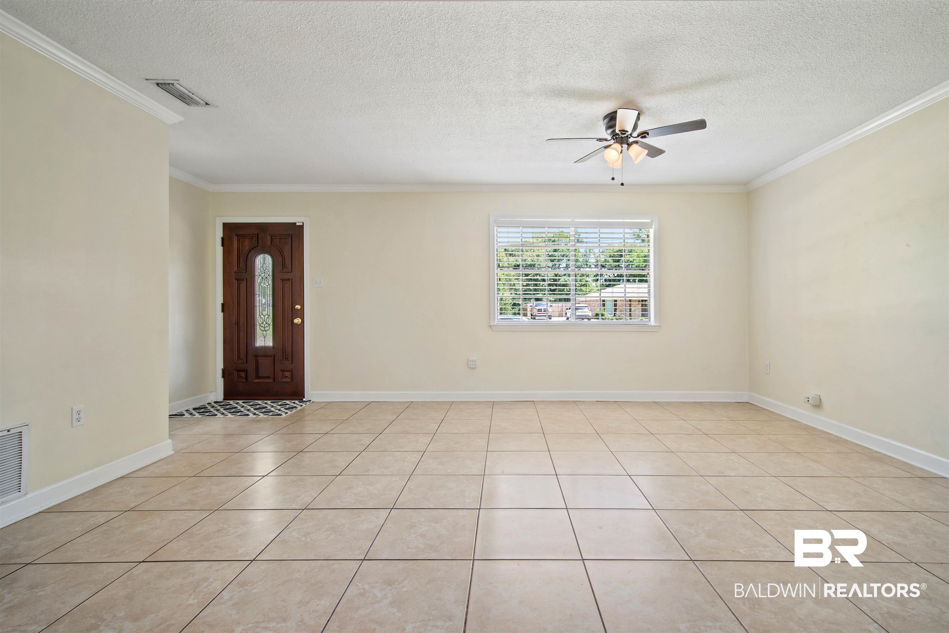 1325 Pawnee Circle Saraland, AL 36571 - Photo 5 of 26 Entrance foyer featuring a ceiling fan, a textured ceiling, ornamental molding, and light tile patterned floors