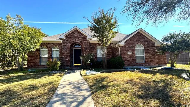 a front view of house with yard and trees in the background