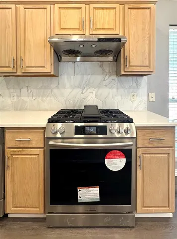 a stove top oven sitting inside of a kitchen