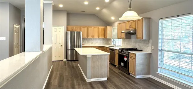 a kitchen with stainless steel appliances granite countertop sink stove and refrigerator