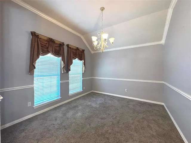 a view of an empty room with a window and chandelier