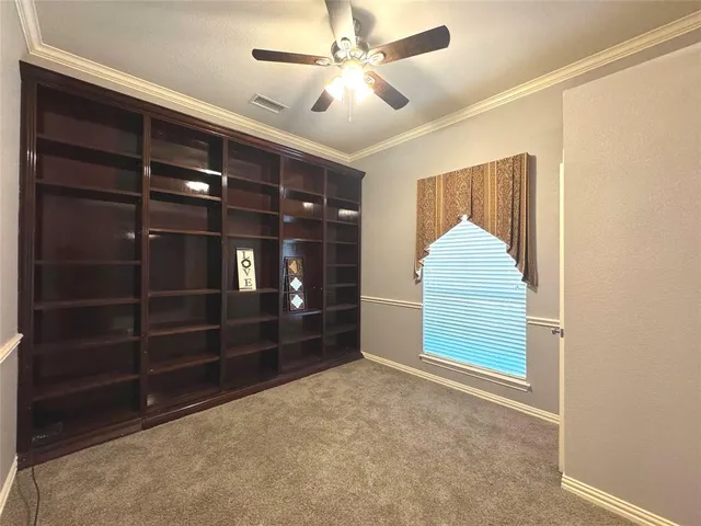a view of an empty room with closet and a window