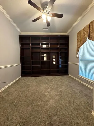 a view of an empty room with closet and a window
