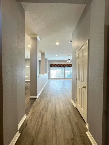 a view of a hallway with wooden floor
