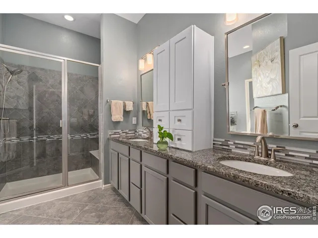a bathroom with a granite countertop sink a mirror and a bathtub