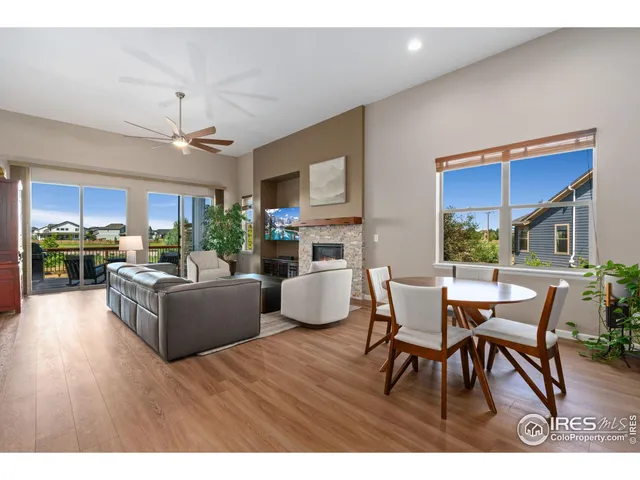 a living room with furniture wooden floor and a kitchen view
