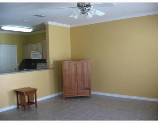 a view of an empty room with wooden floor and a chandelier