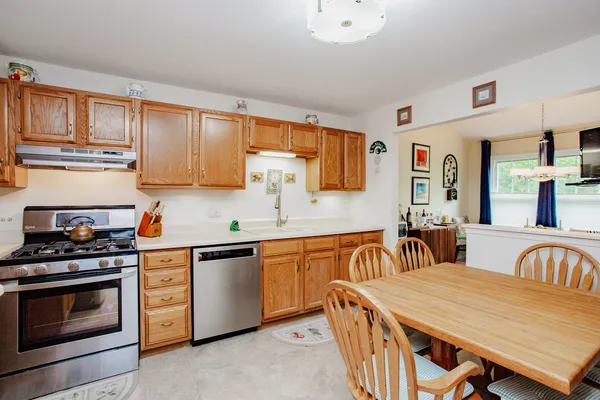 a kitchen with stainless steel appliances granite countertop a stove a sink dishwasher and cabinets with wooden floor