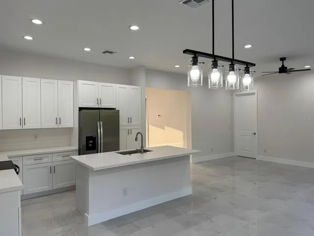 a kitchen with kitchen island a counter top space appliances and cabinets